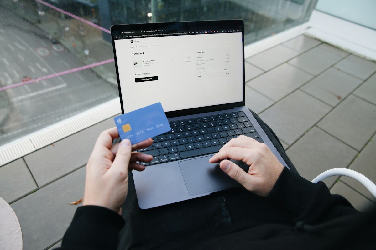 A customer paying online with a laptop and a bank card
